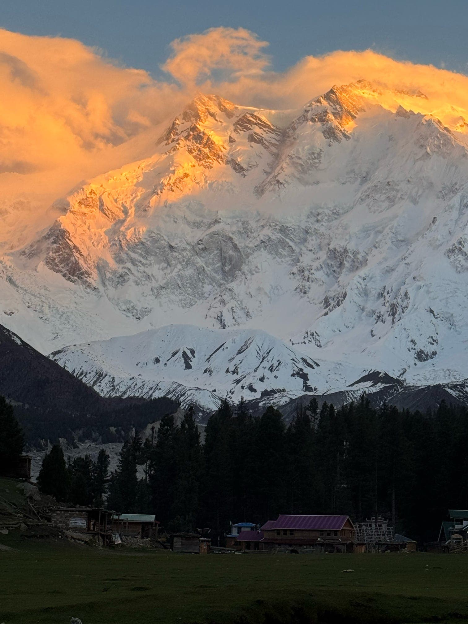 Golden sunrise illuminating Nanga Parbat above a mountain village